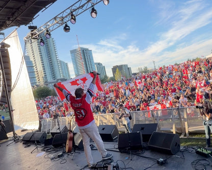 Thomas Lukaszuk raises the Forever Canadian flag over the crowd at the Calgary Concert for Unity